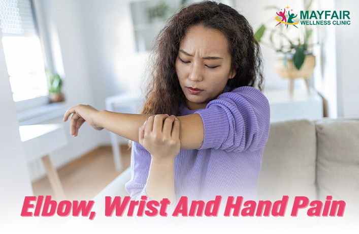 Young woman holding her elbow due to pain, seeking elbow, wrist, and hand pain relief – Mayfair Wellness Clinic