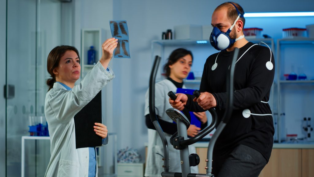 team doctor researchers monitoring endurance man performance sports wearing mask running cross trainer 1 Physiotherapy Cost in Dhaka